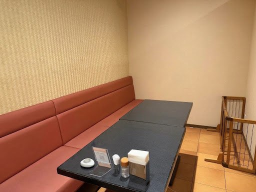 わんちゃんと過ごせる個室。長いソファー席とテーブルがあり、奥にペット用の柵があります。