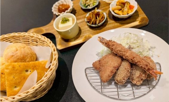 ミックスフライのランチセット。エビフライやアジフライに、小鉢と手作りパンが添えられています。